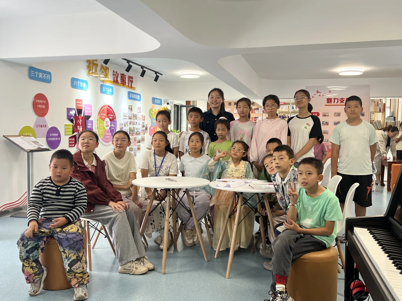 A community piano class gathered around a shared piano